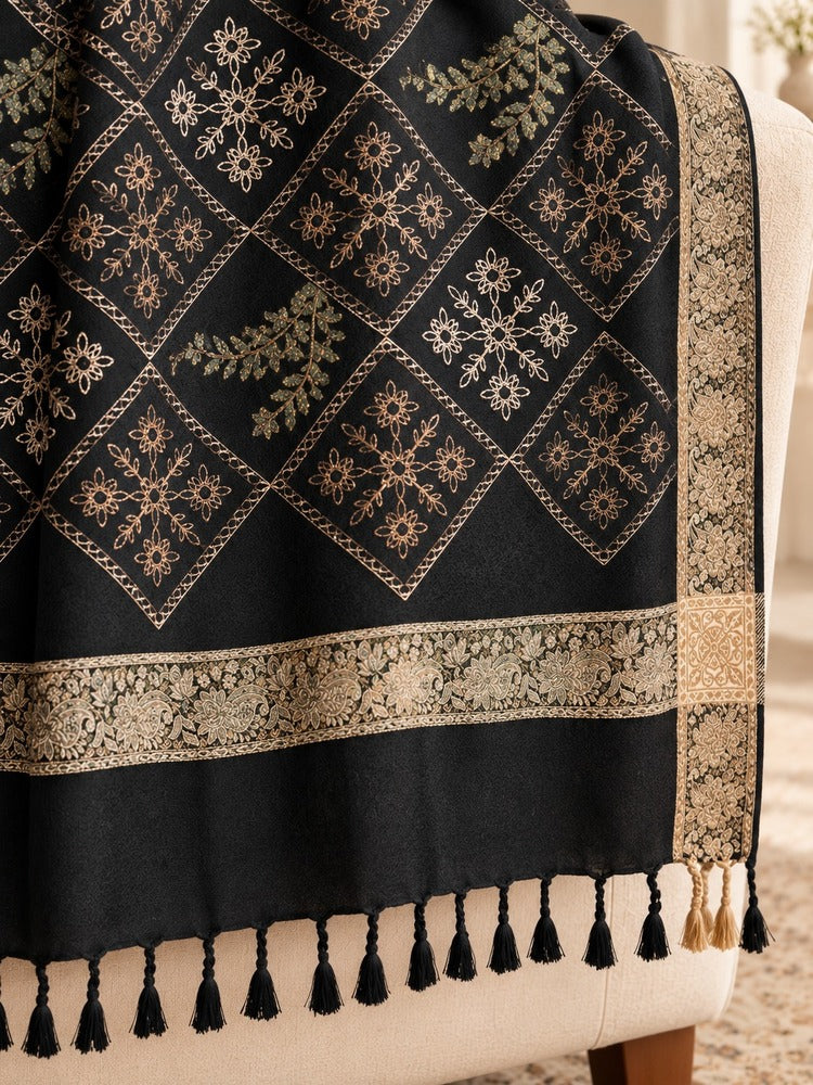 Black shawl for women featuring diamond-shaped floral embroidery, antique-gold patterned borders and black tassels.